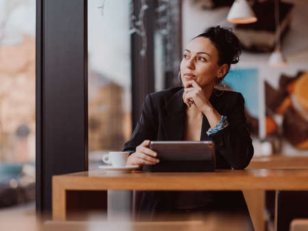 Latina woman sitting in a cafe on a break from workの写真素材