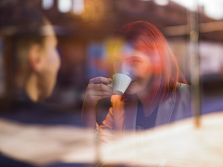 two women sit in a cafe and talk
