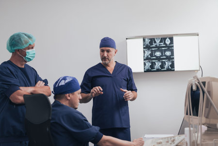 Orthopedist doctor team examining digital X-ray picture in clinic or hospital