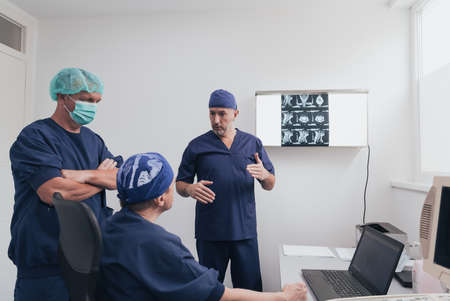 Orthopedist doctor team examining digital X-ray picture in clinic or hospitalの写真素材