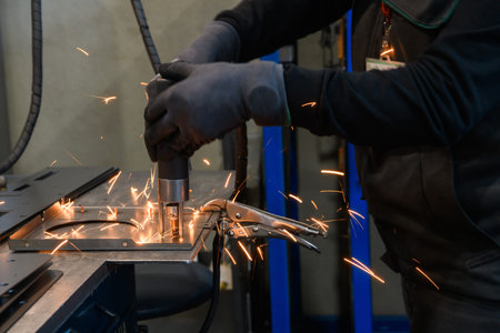 a woman working in the modern metal production and processing industry welds the product and...