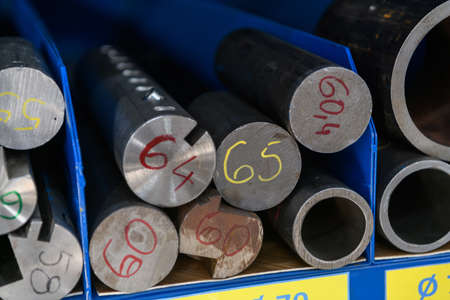 pipes, metal pieces and various metal parts for a CNC machine standing on a shelfの写真素材