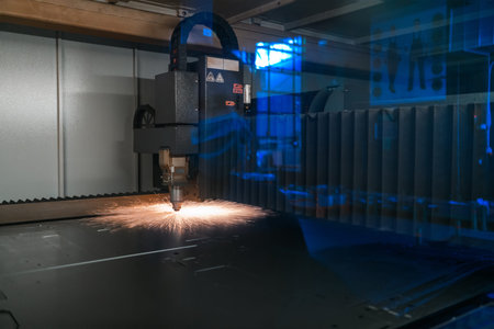 Sparks fly out machine head for metal processing laser metal on metallurgical plant background....