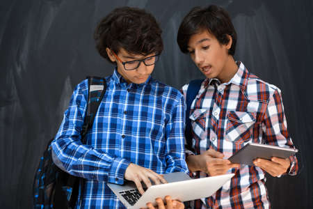 Arabic teenagers team, students group working together on laptop and tablet computer online classroom education conceptの写真素材