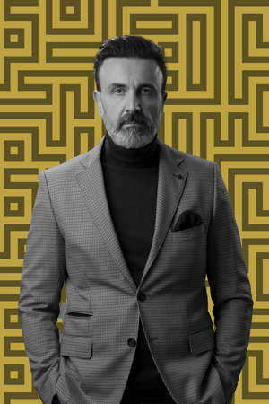 Black and white portrait of a stylish elegant senior businessman with a beard and casual business clothes against retro colorful pattern design background gesturing with handsの写真素材