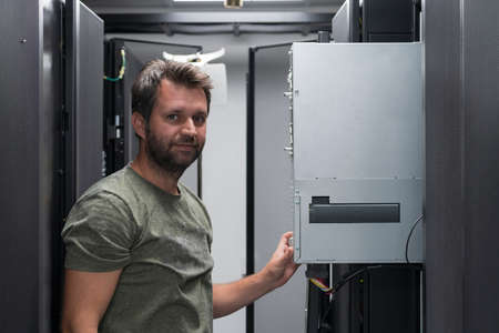 IT engineer working In the server room or data center The technician puts in a rack a new server of corporate business mainframe supercomputer or cryptocurrency mining farm.の写真素材