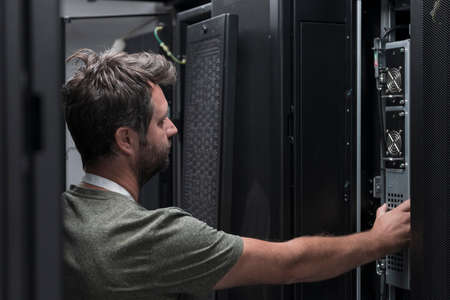 IT engineer working In the server room or data center The technician puts in a rack a new server of corporate business mainframe supercomputer or cryptocurrency mining farm.の写真素材