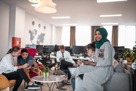 Multiethnic startup business team having brainstorming in relaxation area of modern office interior...