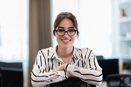 Portrait of businesswoman in casual clothes with glasses at modern startup open plan office...