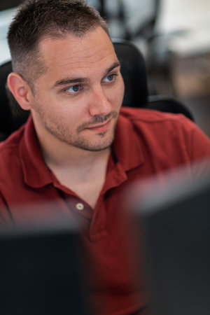Casual business man working on desktop computer in modern open plan startup office interior. Selective focusの写真素材