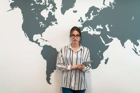 Portrait of businesswoman in casual clothes holding tablet computer at modern startup open plan office interior. Selective focusの写真素材