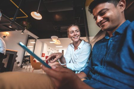 Multiethnic business people man with a female colleague working together on tablet computer in relaxation area of modern startup officeの写真素材