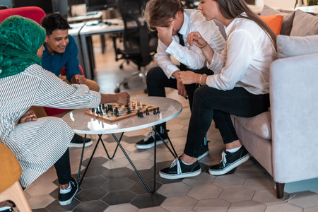 Multiethnic group of business people playing chess while having a break in relaxation area at modern...