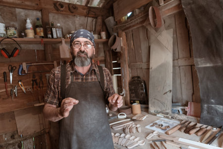 Spoon master in his workshop with wooden products and tools