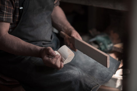 Hands carving cup from wood, working with chisel close up. Wooden workshop. Process of making wooden...