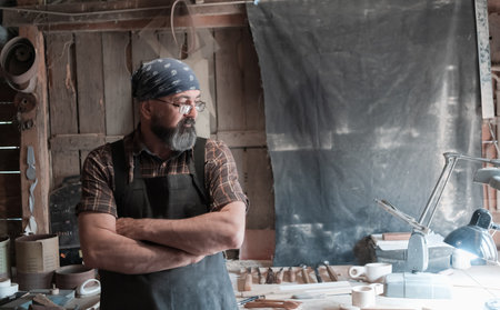 Spoon master in his workshop with wooden products and toolsの写真素材