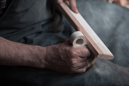 Hands carving cup from wood, working with chisel close up. Wooden workshop. Process of making wooden...