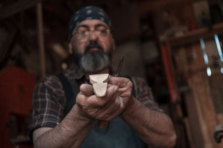 Spoon craft master in his workshop with handmade wooden products and tools workingの写真素材