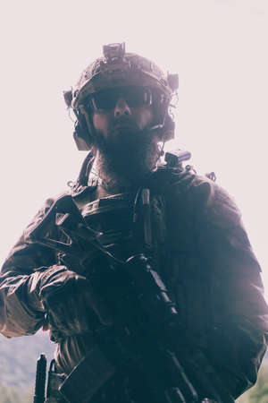 War concept. A bearded soldier in a special forces uniform fighting an enemy in a forest area. Selective focusの写真素材