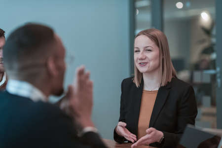 Successful team. Group of young multi-ethnic business people working and communicating together in creative office. Selective focusの写真素材