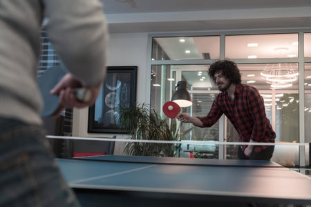 Two young start up business man playing  table tennis   tennis at modern creative office space...