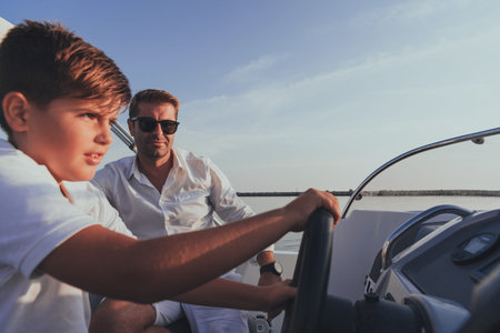 Father and son enjoy their vacation together while riding a luxury boat at sea. Selective focus