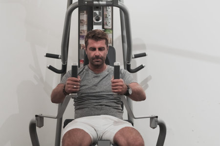 Struggling with age. Confident senior man exercising in health club. Selective focus