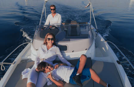 A happy family enjoys a vacation together while riding a luxury boat at sea. Selective focusの写真素材