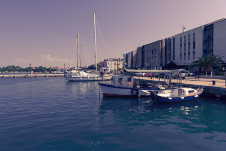 A photograph of a ship and a luxury yacht anchored in port. Beautiful photo of a Mediterranean port
