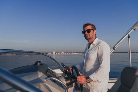 A determined senior businessman in casual clothes and sunglasses enjoys his vacation driving a...