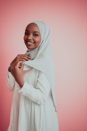 Portrait of young modern muslim afro beauty wearing traditional islamic clothes on plastic pink...
