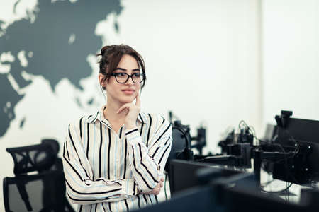 Portrait of businesswoman in casual clothes with glasses at modern startup open plan office interior. Selective focusの写真素材