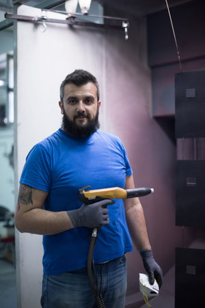 The painter paints the iron element. Industrial painting parts. Metal designs