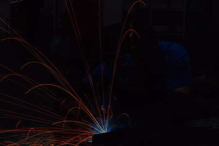 Professional Heavy Industry Welder Working Inside factory, Wears Helmet and Starts Welding....