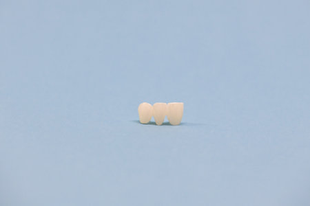 Metal free ceramic teeth implant dental crowns isolated on a blue background.の写真素材