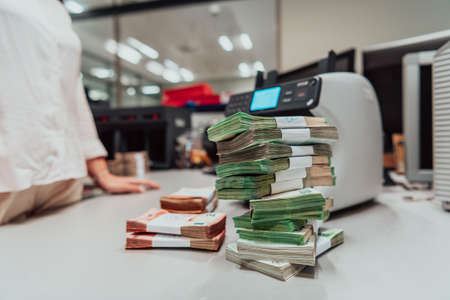 Sorted banknotes placed on the table after it is counted on the electronic money counting machineの写真素材