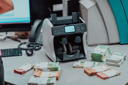 Sorted banknotes placed on the table after it is counted on the electronic money counting machineの写真素材