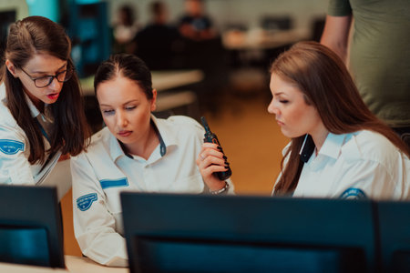 Group of female security operators working in a data system control room Technical Operators Working...