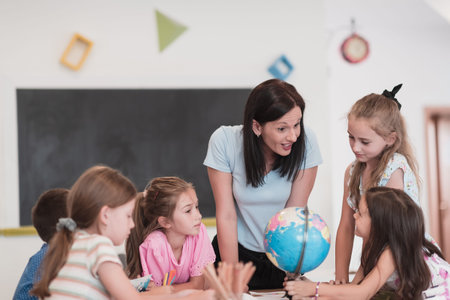 Female teacher with kids in geography class looking at globe. Side view of group of diverse happy...