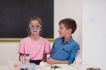 Elementary School Science Classroom: Enthusiastic Teacher Explains Chemistry to Diverse Group of...