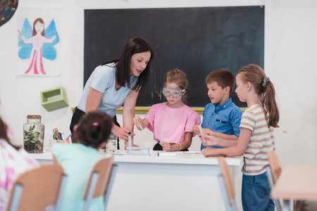 Elementary School Science Classroom: Enthusiastic Teacher Explains Chemistry to Diverse Group of...