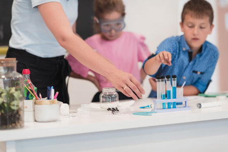 Elementary School Science Classroom: Enthusiastic Teacher Explains Chemistry to Diverse Group of...