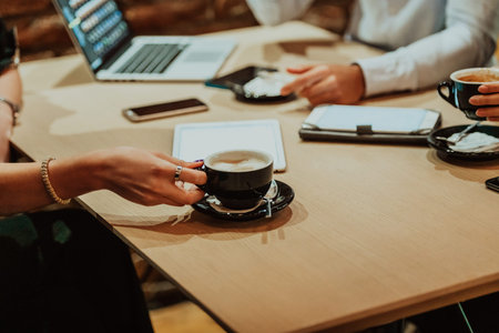Happy businesspeople smiling cheerfully during a meeting in a coffee shop. Group of successful...
