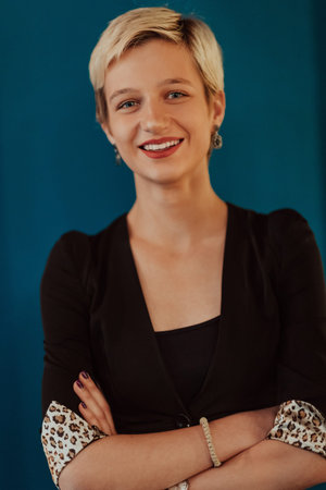 Pretty business woman, successful confidence with arms crossed on modern blue mat background....