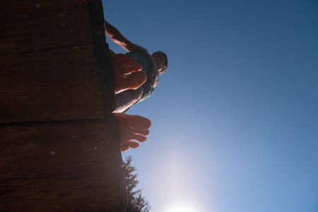 young teen boy ready for a jump in the river on a summer sunny day on vacation superhero shot with selective focus on water drops.の写真素材