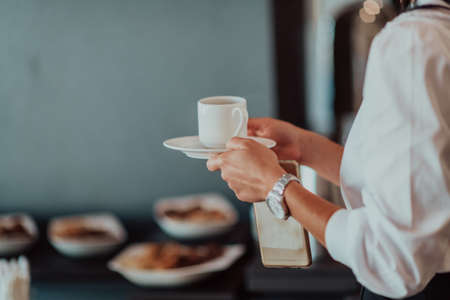 Close-up photo of businesswoman serving themselves in a modern hotel during a dinner party. Selective focusの写真素材