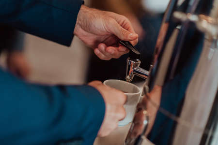 Close-up photo of businessmen serving themselves in a modern hotel during a dinner party. Selective focusの写真素材