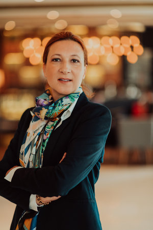 Portrait of business senior woman with crossed arms standing in modern corporation. Selective focusの写真素材