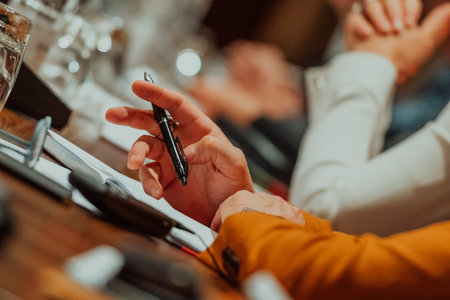 Close-up of male hands with pen over document. Selective focus