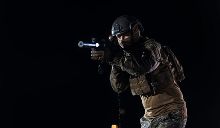 Army soldier in Combat Uniforms with an assault rifle, plate carrier and combat helmet going on a...
